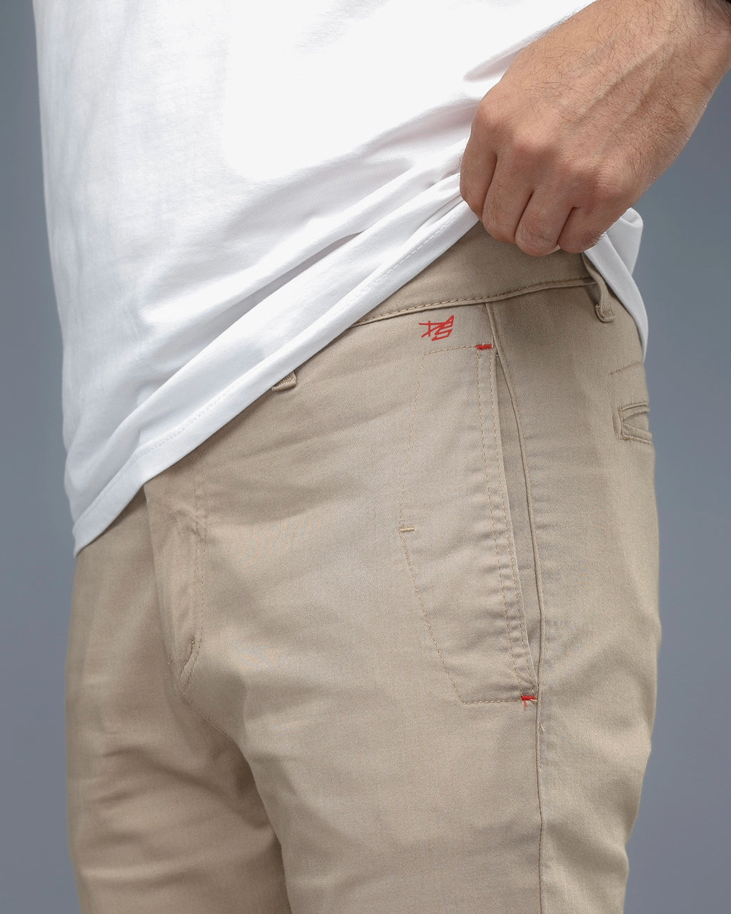 Beige pants with a brand logo on a gray background
