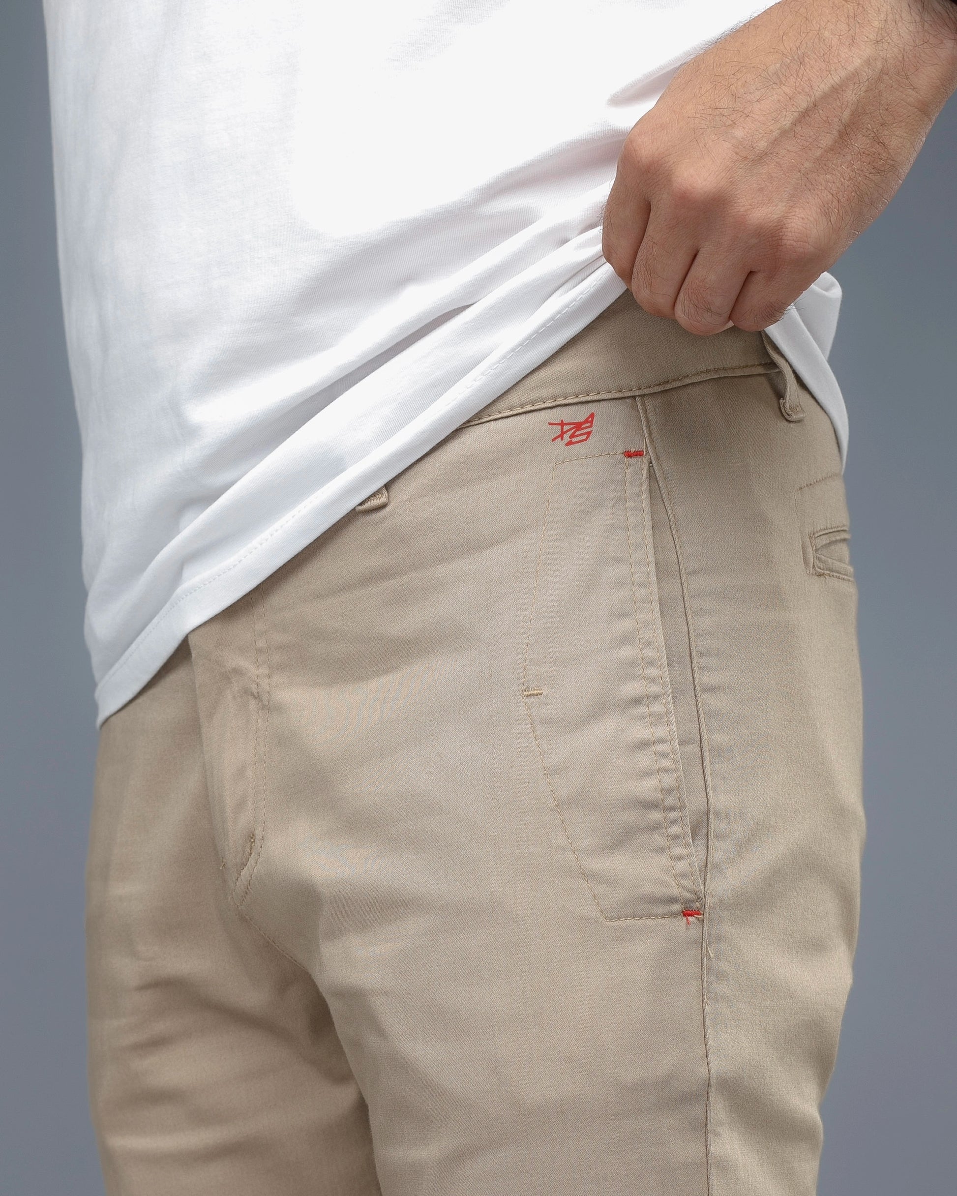 Beige pants with a brand logo on a gray background