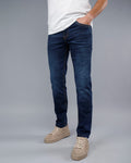 Person wearing blue jeans and a white shirt on a gray background