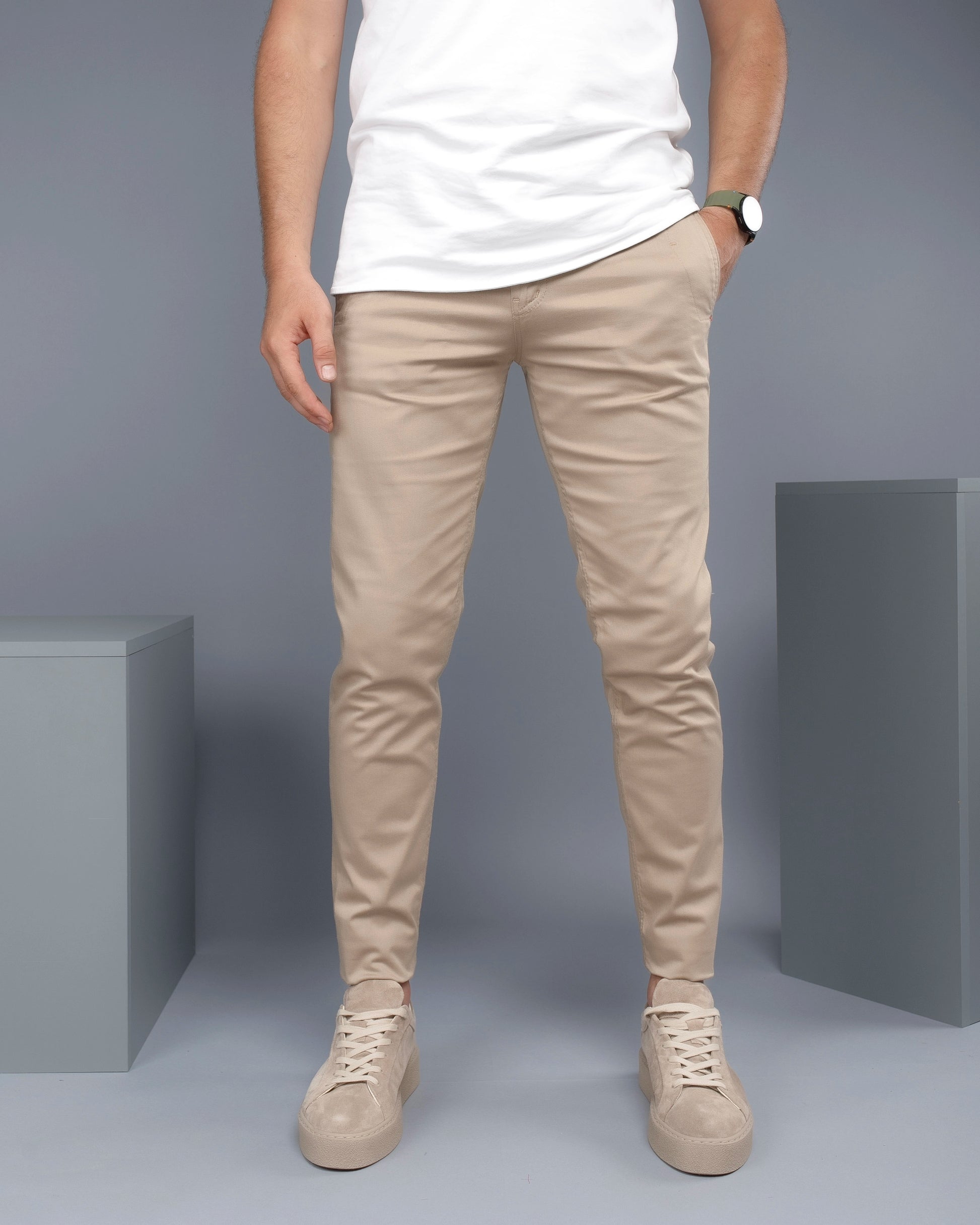 Person wearing beige pants and shoes on a gray background