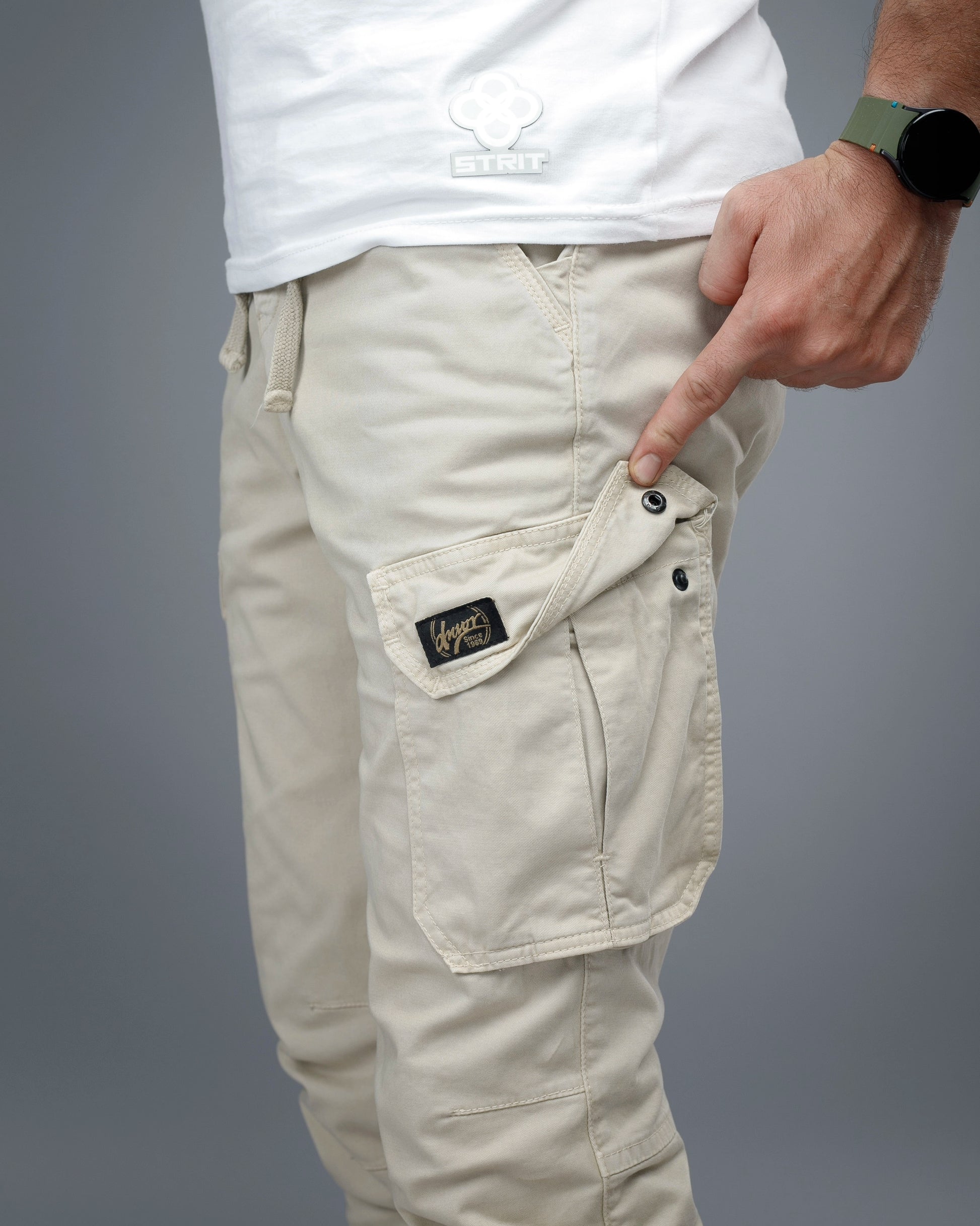 Beige cargo pants with a visible brand logo on a gray background