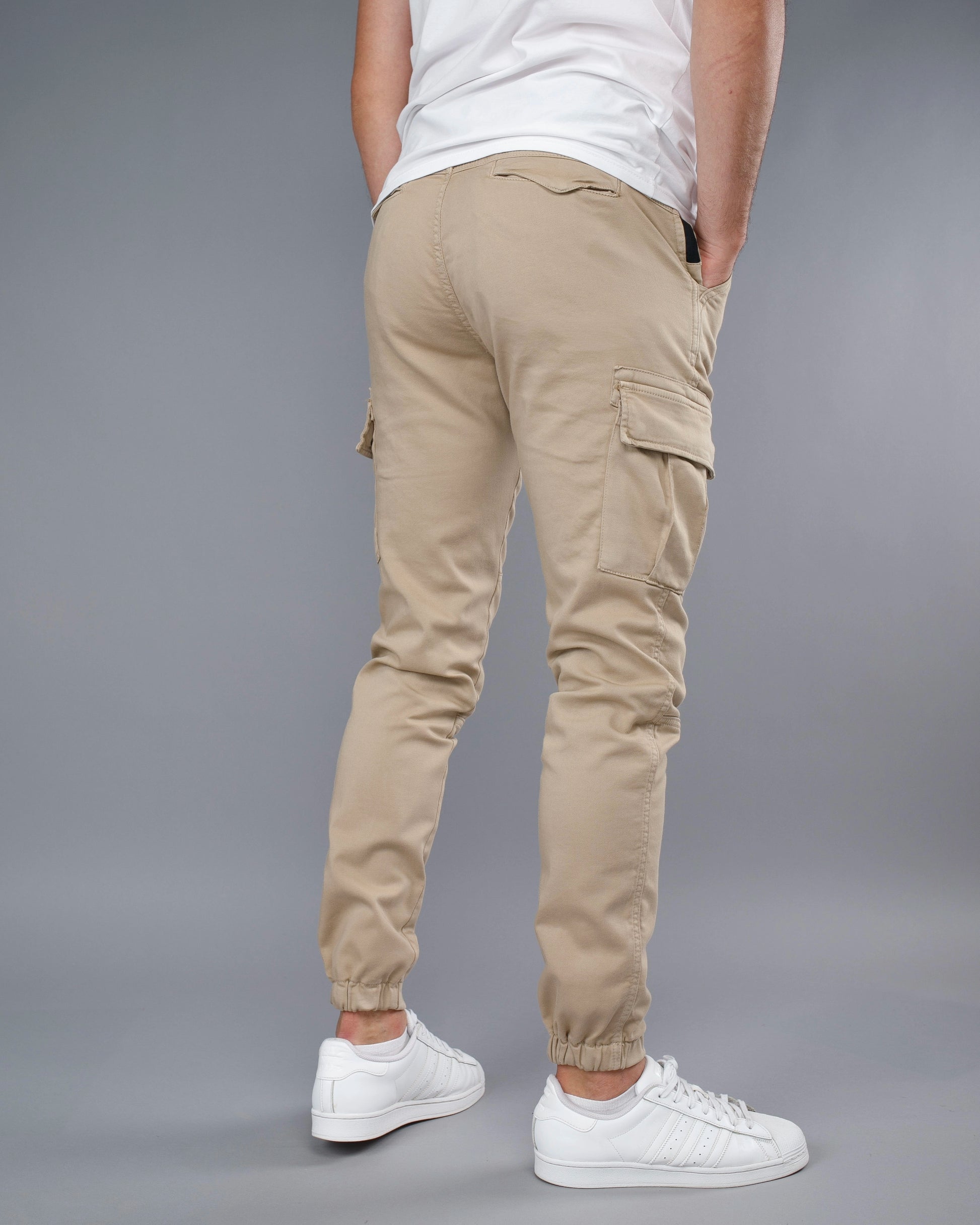 Beige cargo pants with a gray background