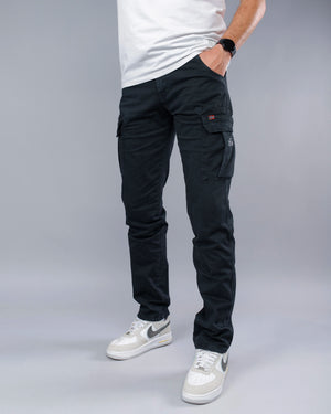 Person wearing black cargo pants and white sneakers on a gray background
