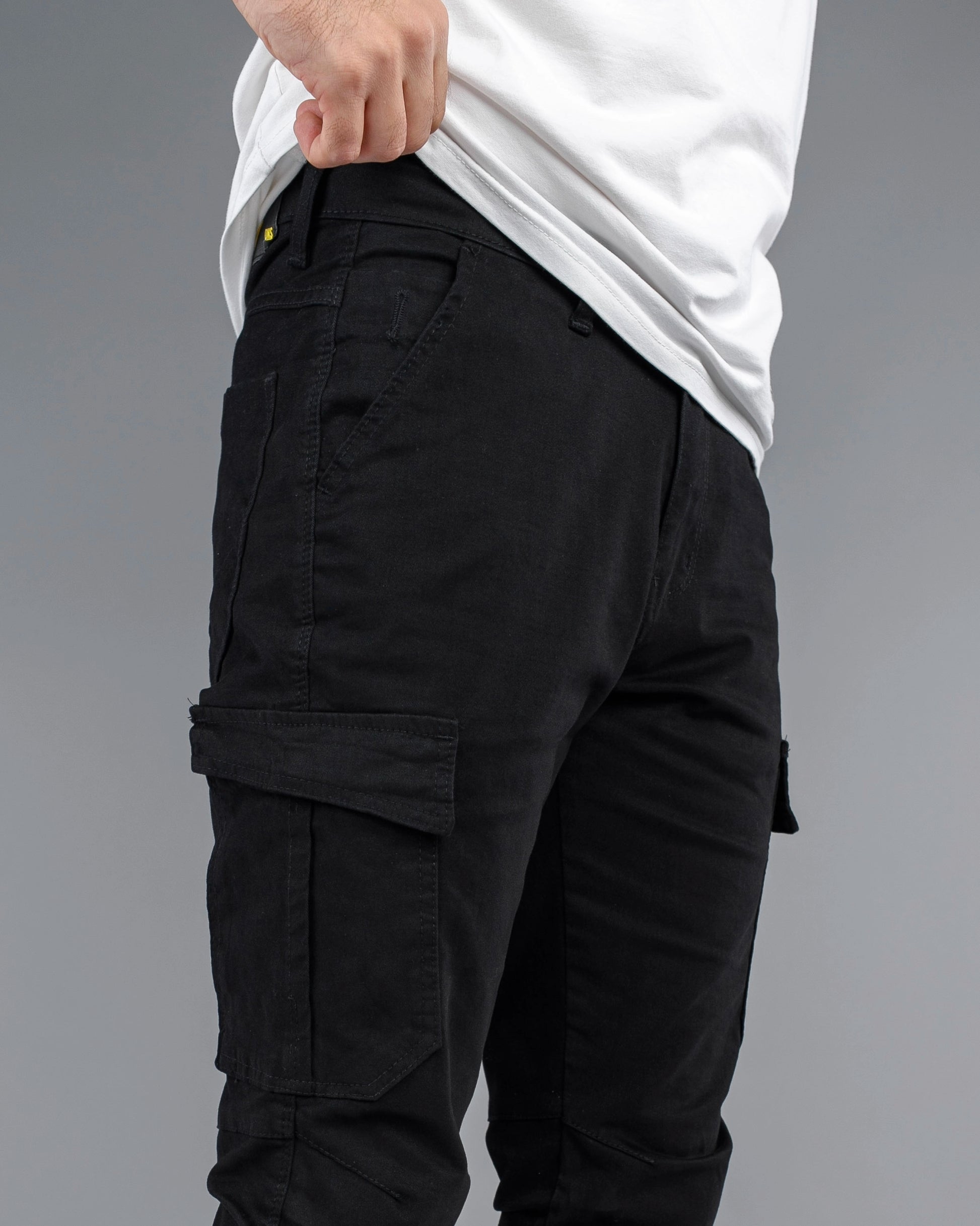 Black cargo pants worn by a person on a gray background