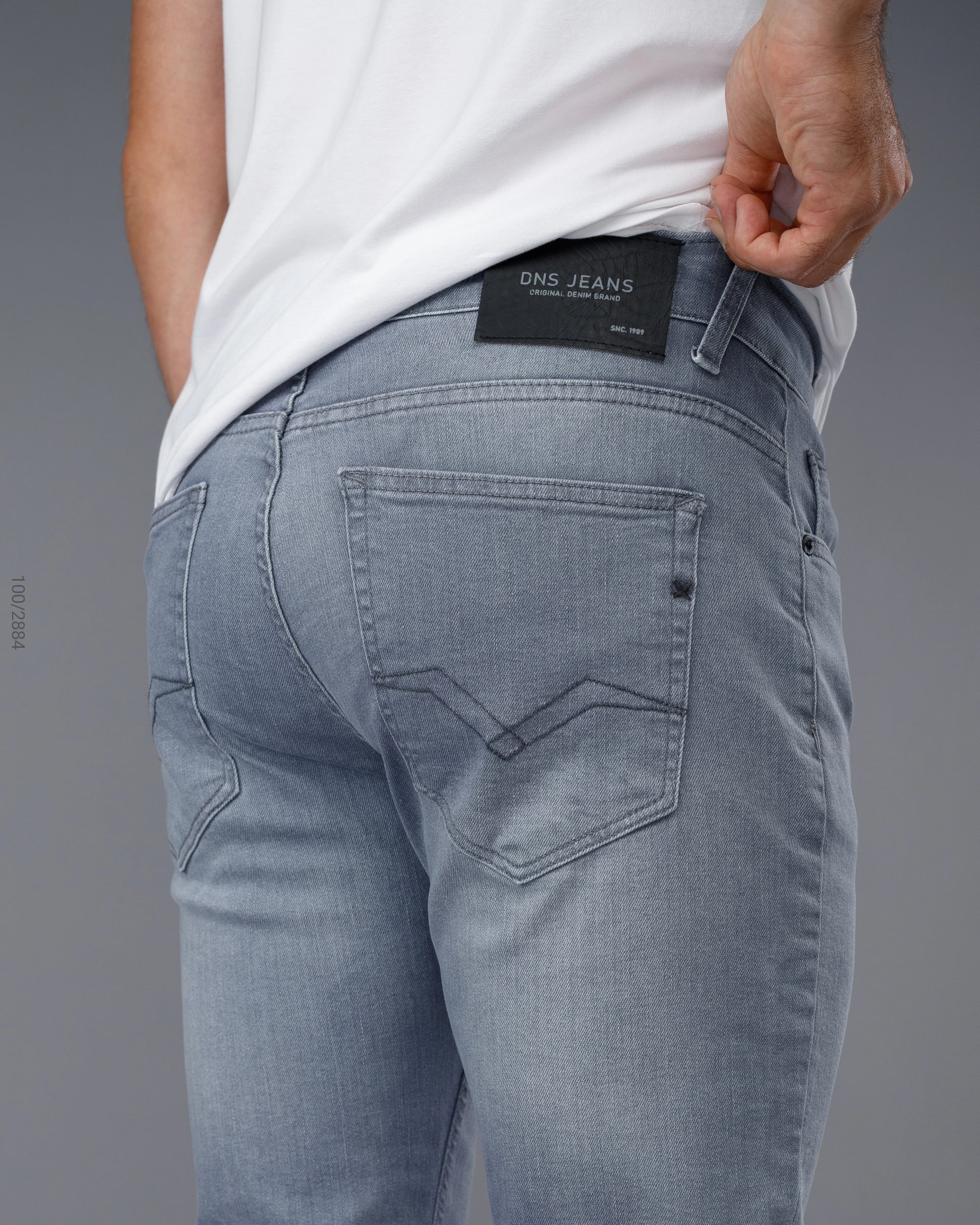 Light blue jeans with a visible brand label on a gray background