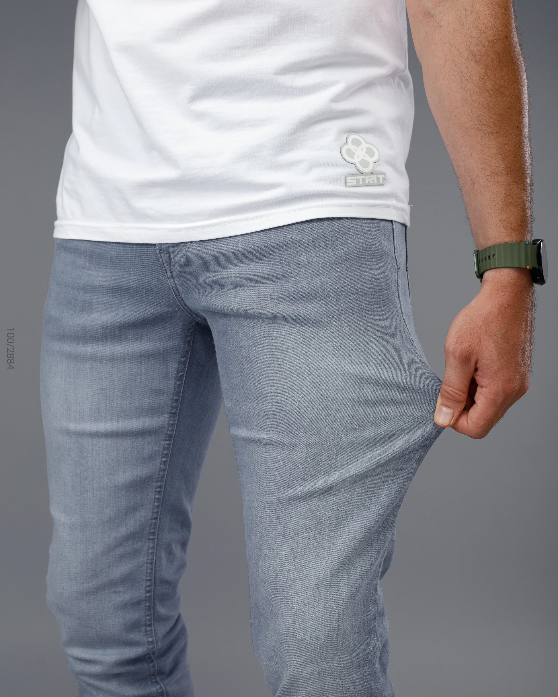 Person wearing light blue jeans and a white t-shirt on a gray background